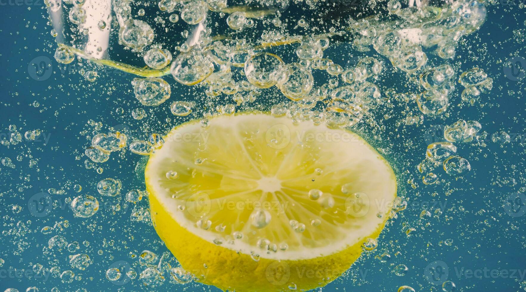 Underwater lemon slice in soda water or lemonade with bubbles. photo