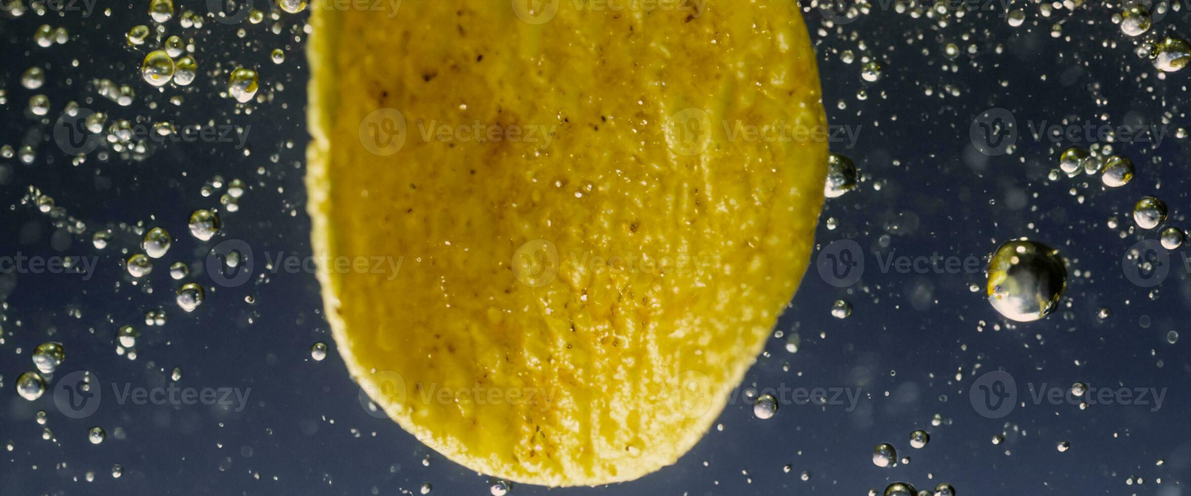 Deep fried potato chips under golden oil water. photo