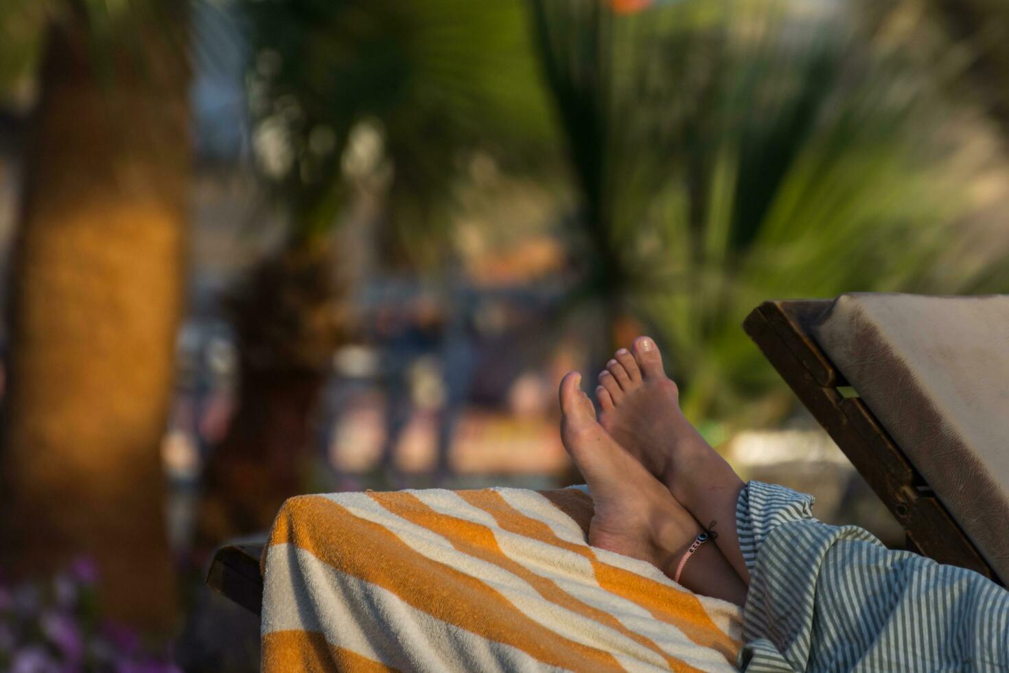feet from a woman lying at the pool on vacation photo