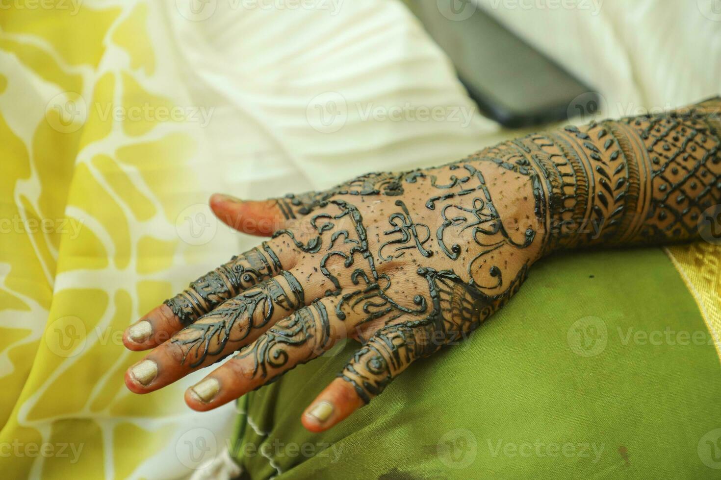 An Indian bride showing her hand's mehndi tattoos design photo