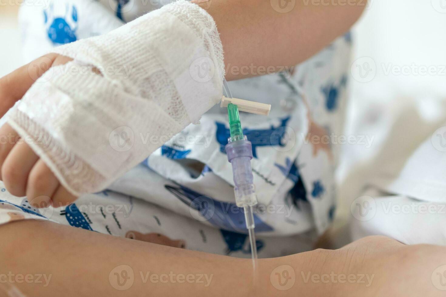 Close up child hand with saline IV solution in hospital photo