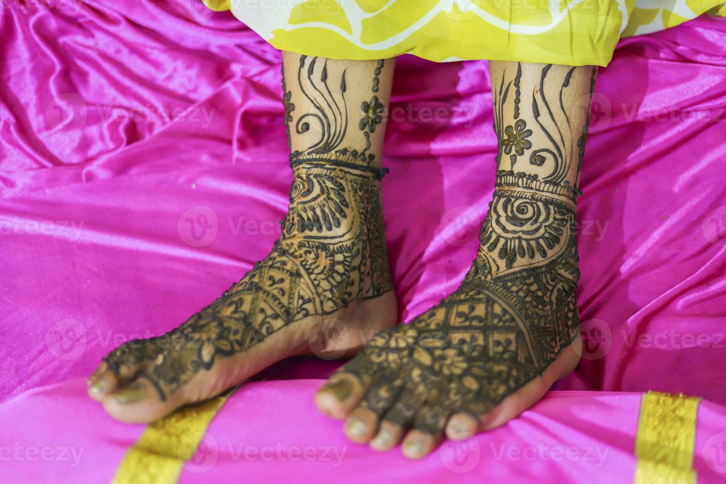 Indian bride showing feet mehndi design her wedding ceremony photo
