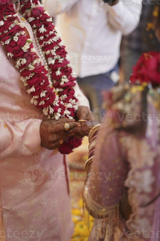 Indian groom putting ring on Indian bride photo