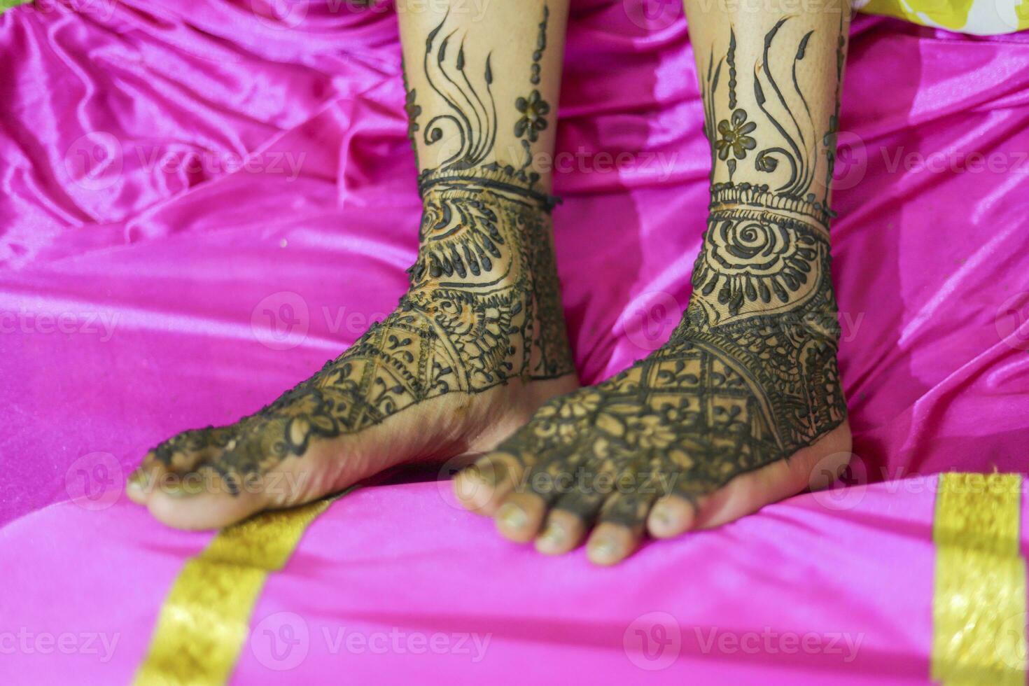 Indian bride showing feet mehndi design her wedding ceremony photo