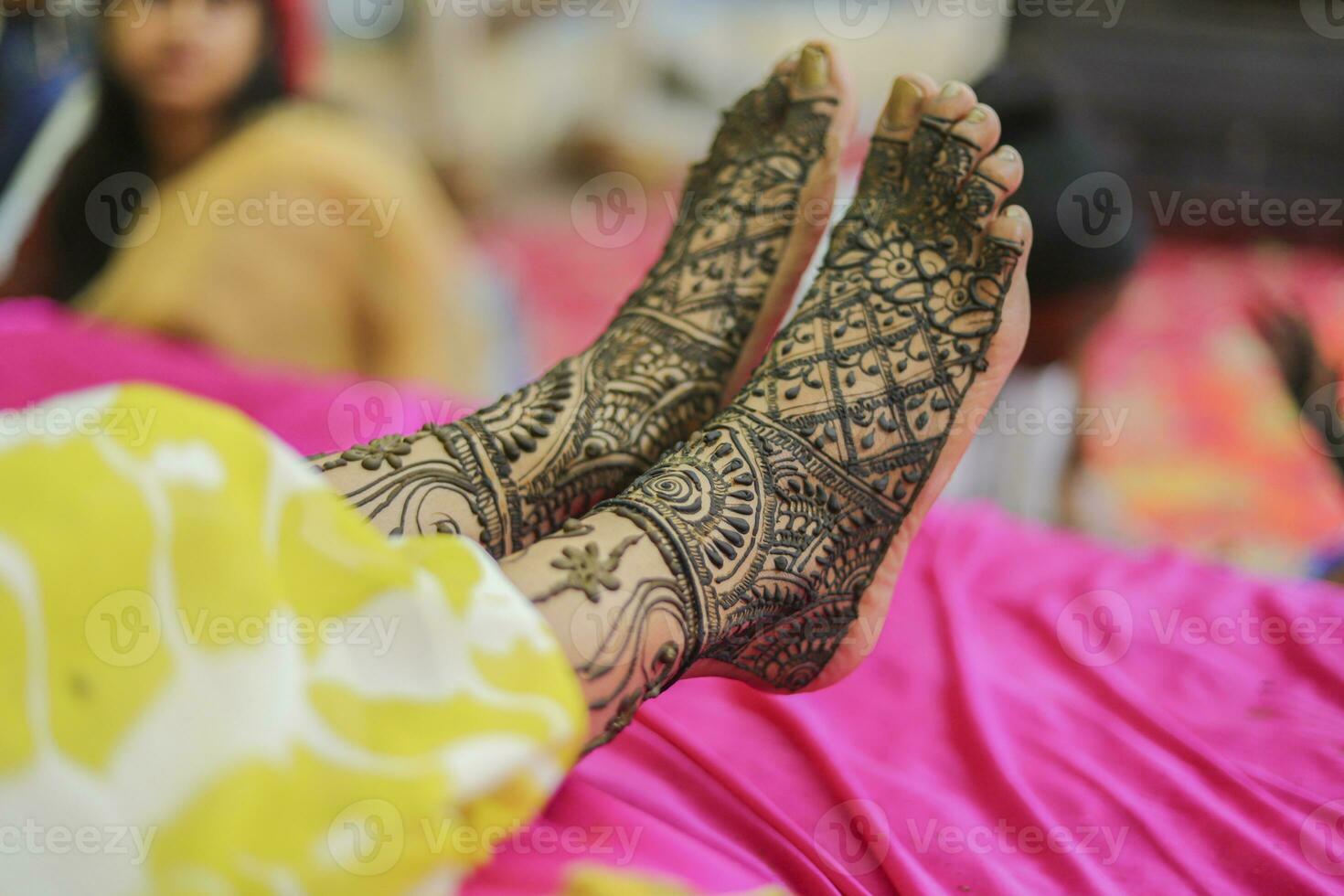 Indian bride showing feet mehndi design her wedding ceremony photo