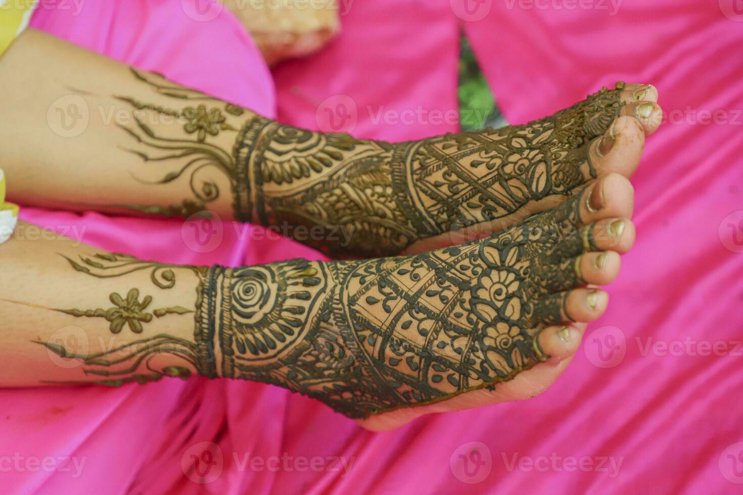 Indian bride showing feet mehndi design her wedding ceremony photo