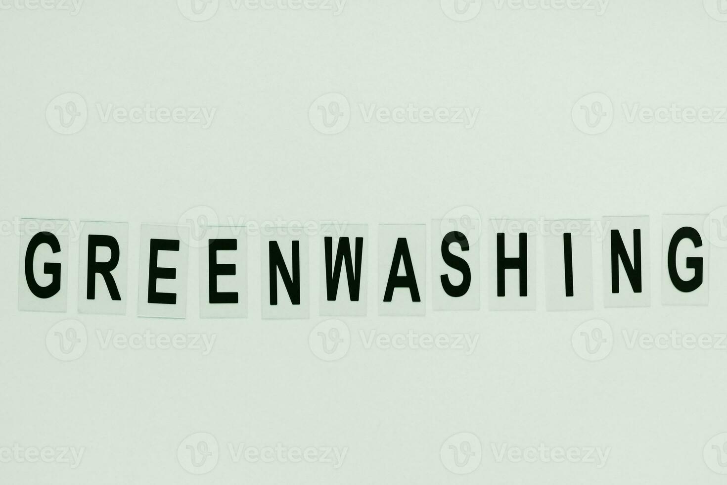Text GREENWASHING on green background. Green PR, green marketing and misleading information about company products being ecofriendly concept photo