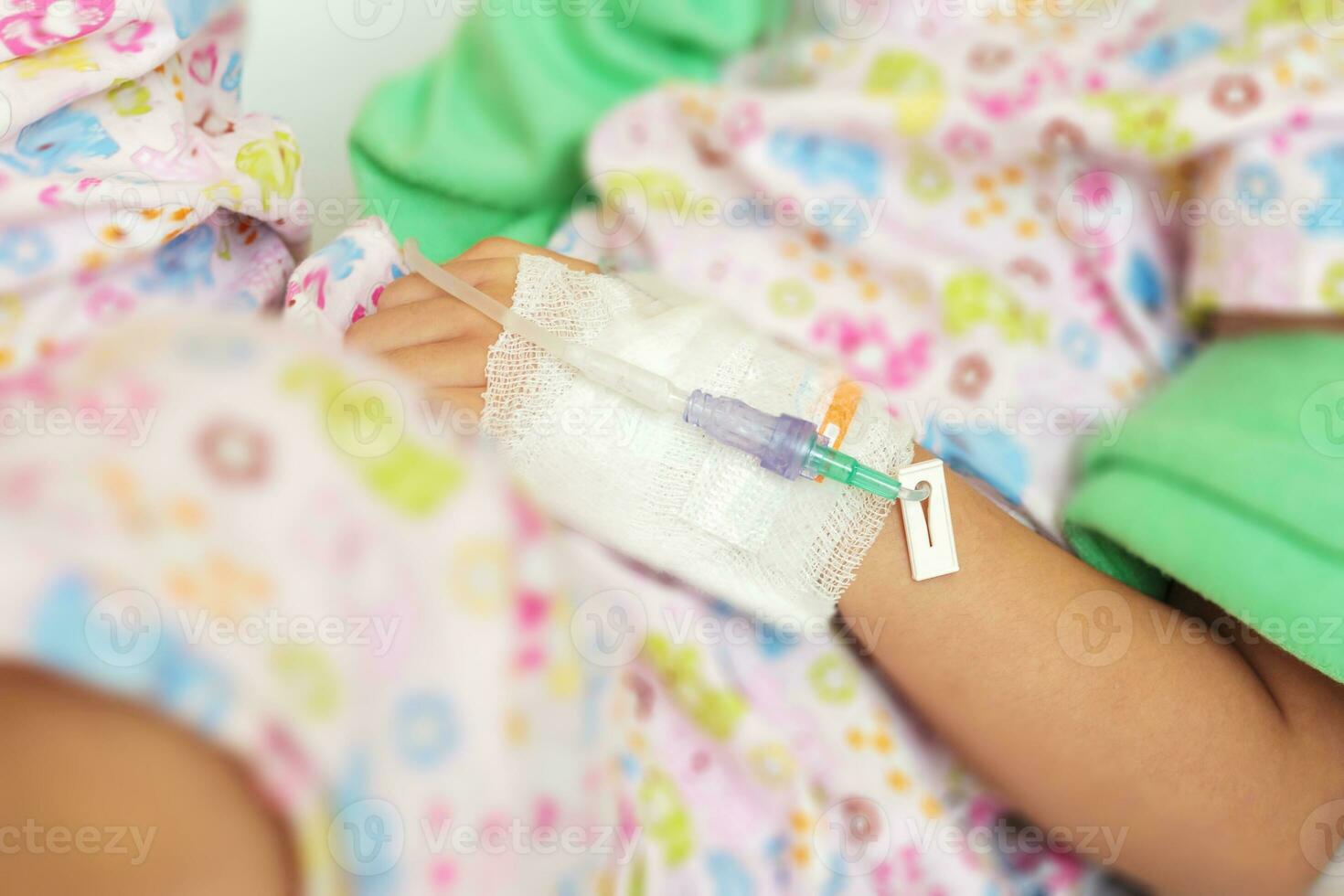 Close up child hand with saline IV solution in hospital photo