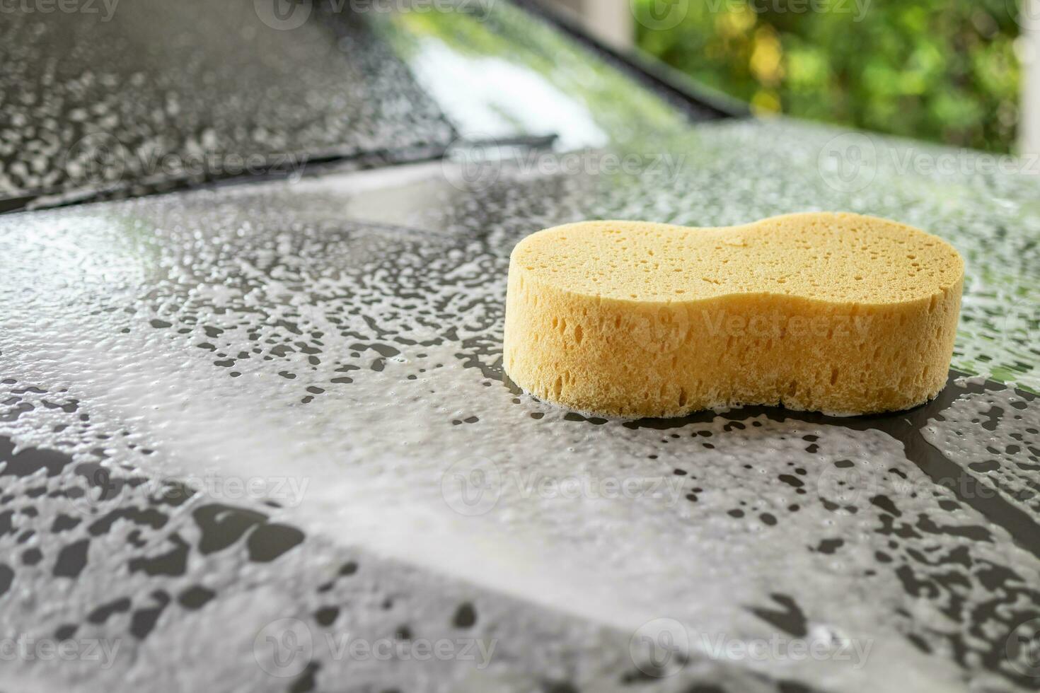 car cleaning and washing with yellow sponge and foam soap photo