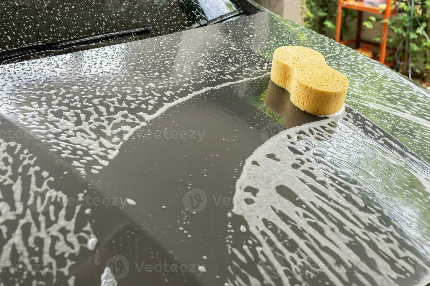 car cleaning and washing with yellow sponge and foam soap photo