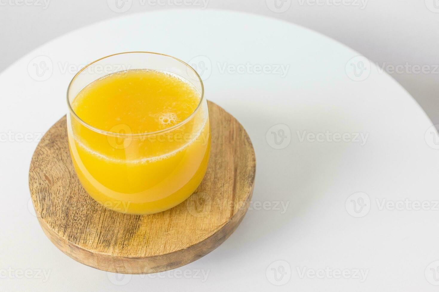 Fresh squeezed orange juice in glass on table on white background. Healthy beverage for breakfast photo