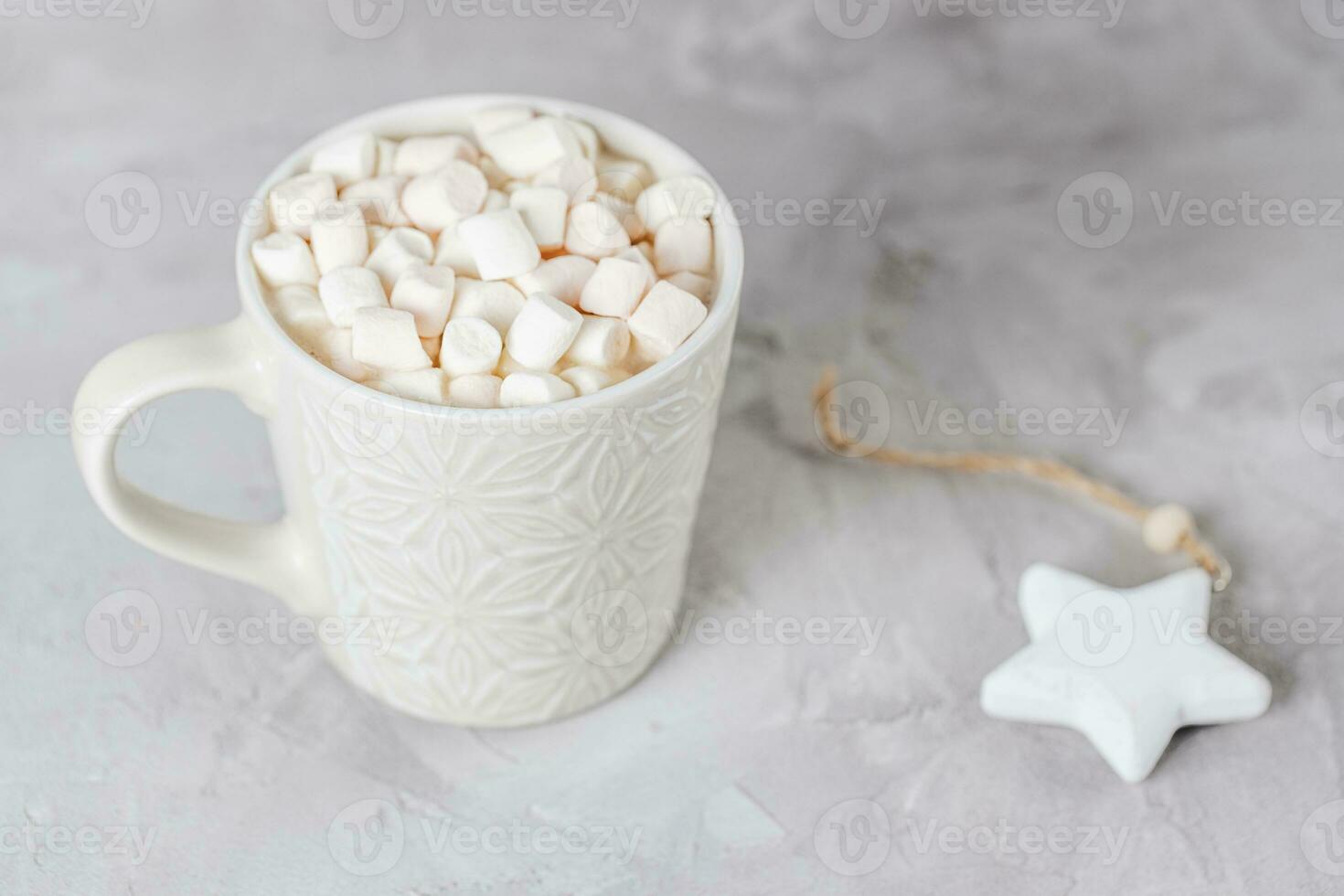 Cup of cocoa or chocolate with marshmallows and star Christmas decoration, light gray background. Winter hot beverage concept Flat lay, top view, copy space photo