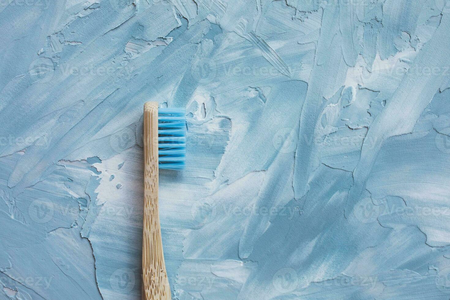 uno azul bambú cepillo de dientes. el plastico gratis, cero residuos concepto. parte superior vista, blanco y azul fondo, Copiar espacio foto