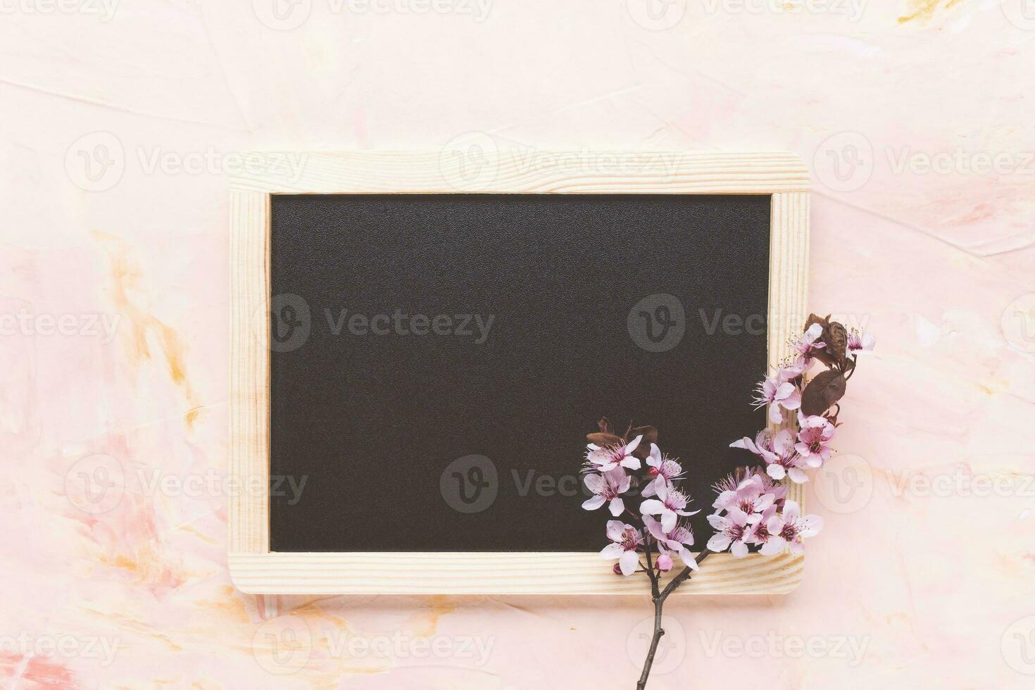 Empty message black board and fresh spring flowers photo