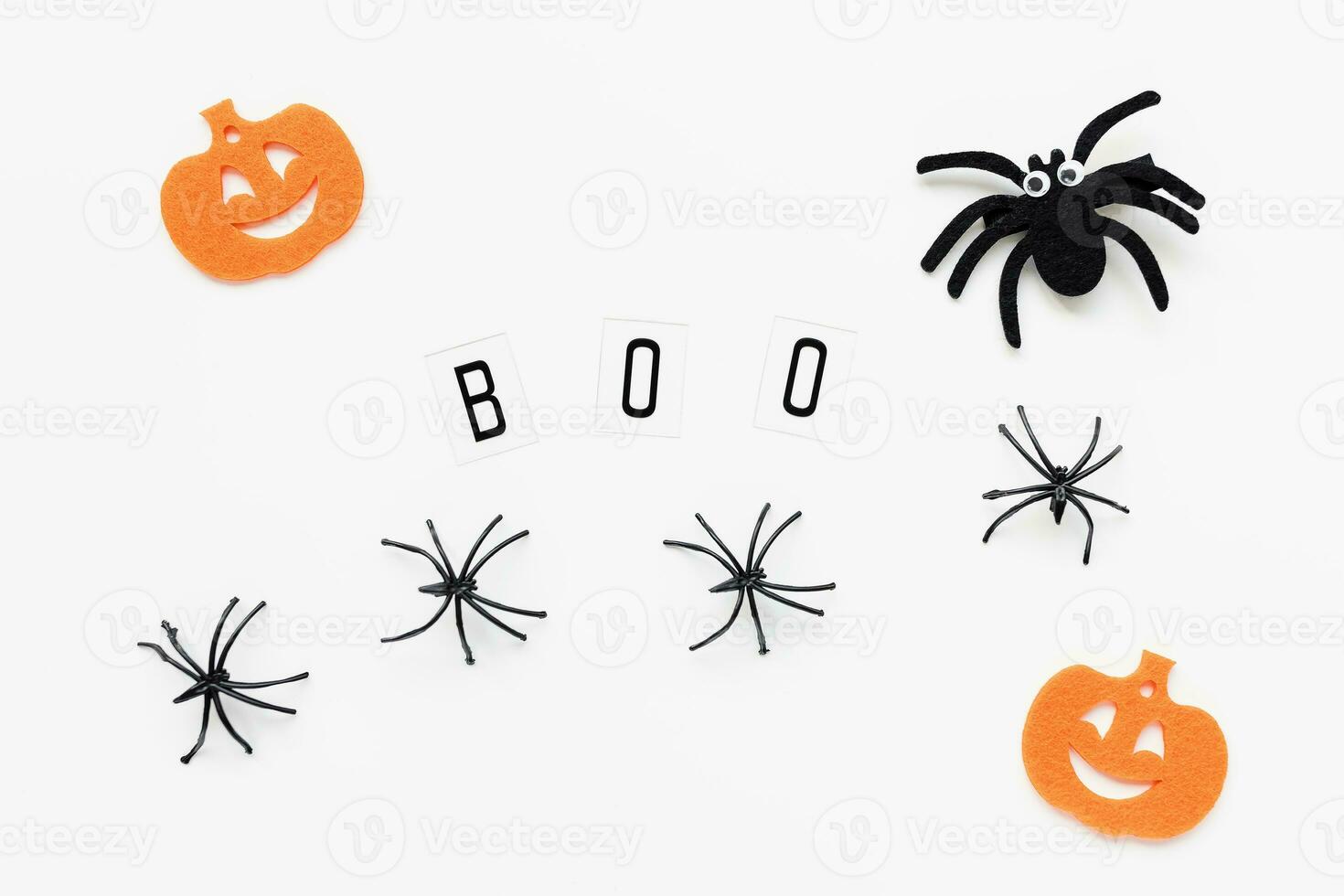 Pumpkins, spiders and text BOO on white background photo