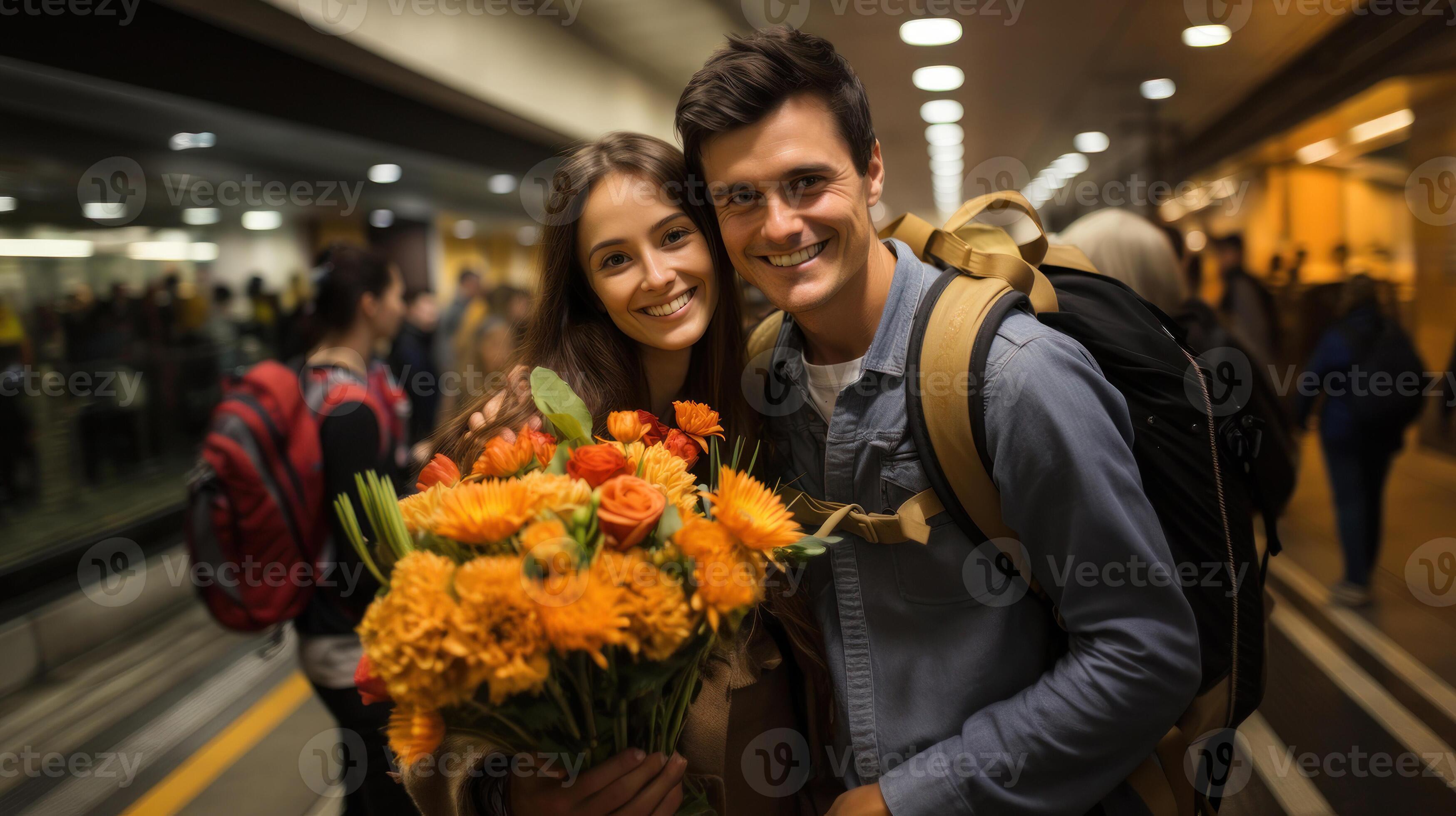 Young couple holding bouquet of flowers in subway or airport. Guy meets