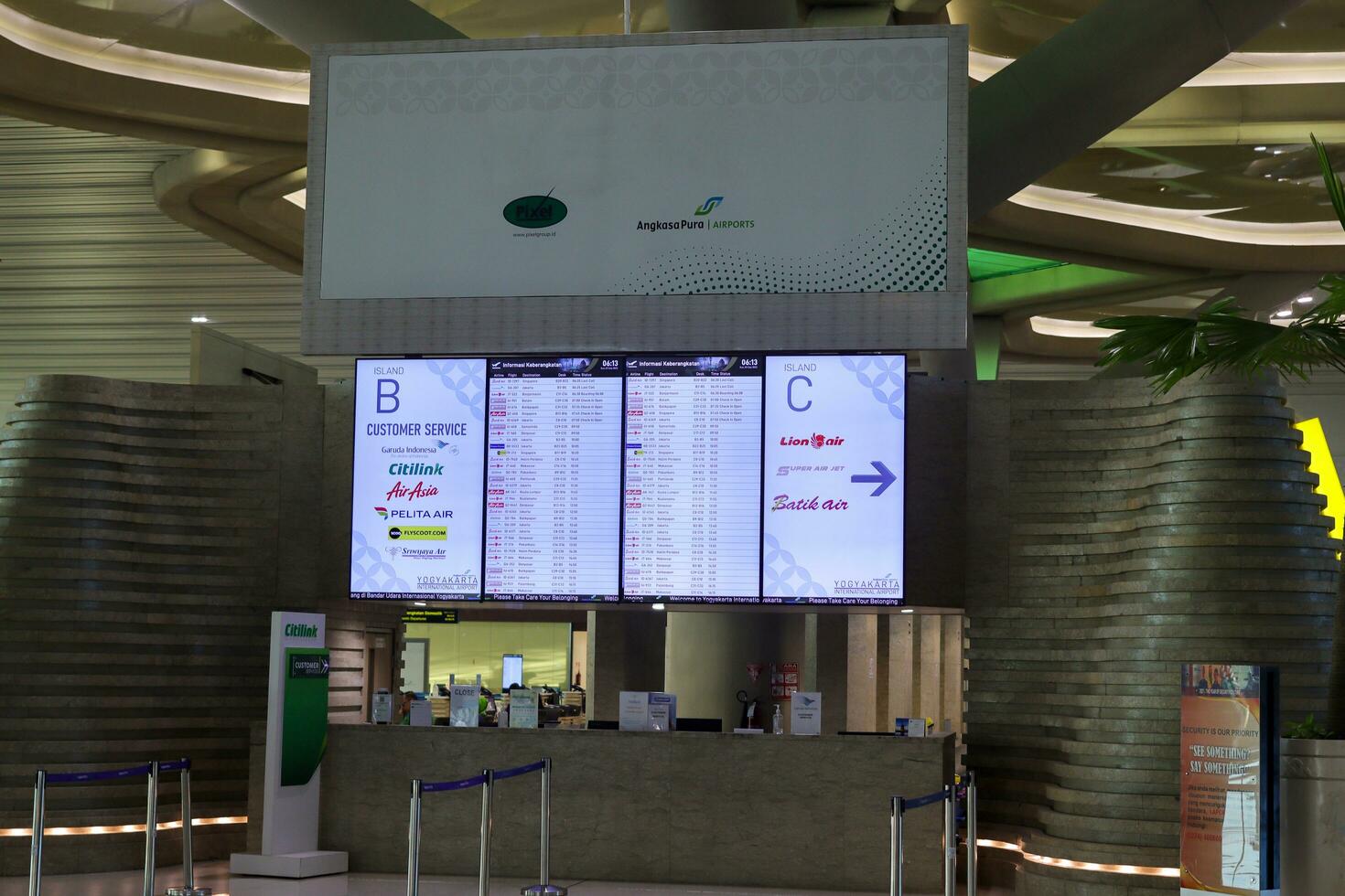 Flight information display system showing airline schedule. Yogyakarta International Airport YIA is a modern facility serving international and domestic flights. Kulon Progo - Indonesia 09 03 2023 photo