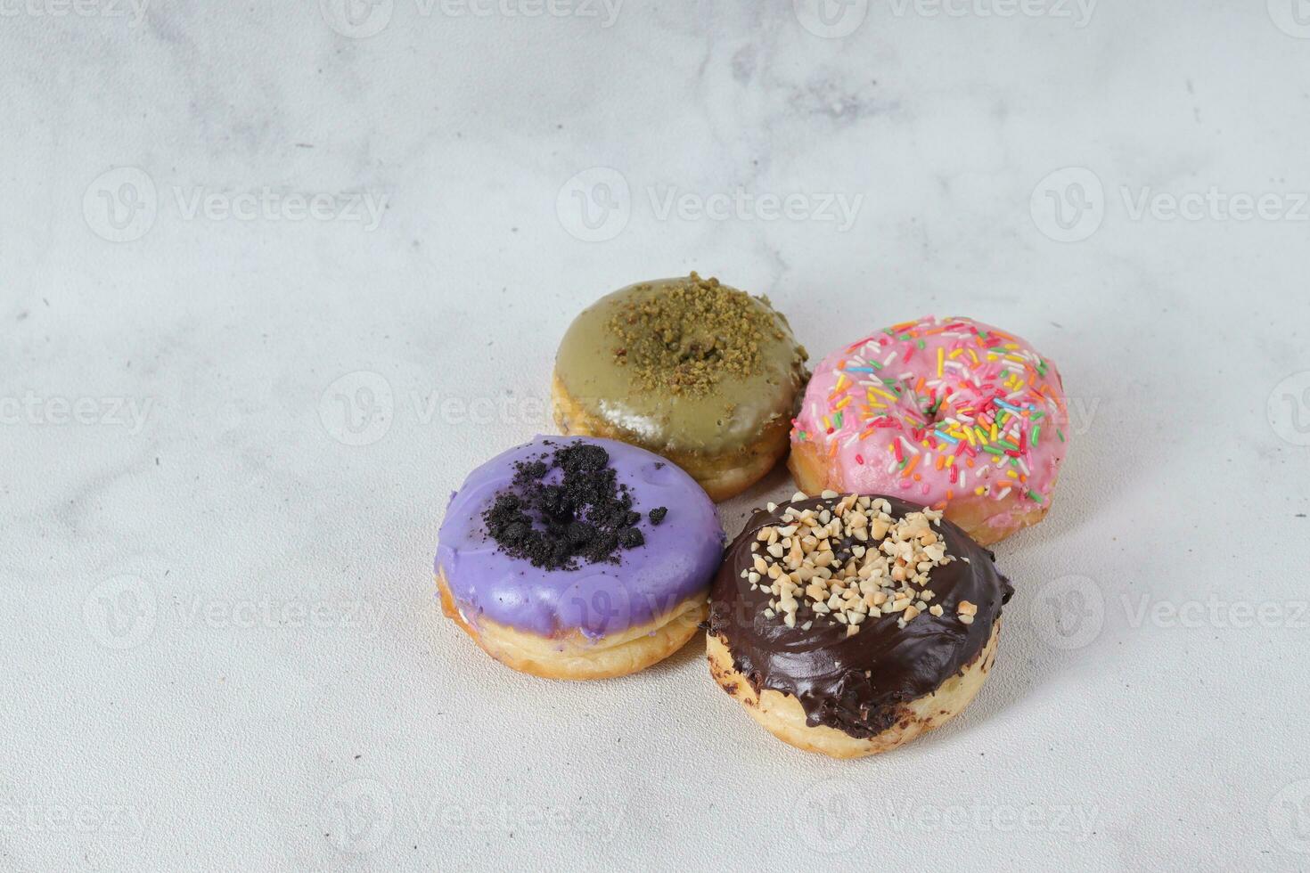 Delicious sweet donuts with different flavors on a table. Isolated image on white background photo