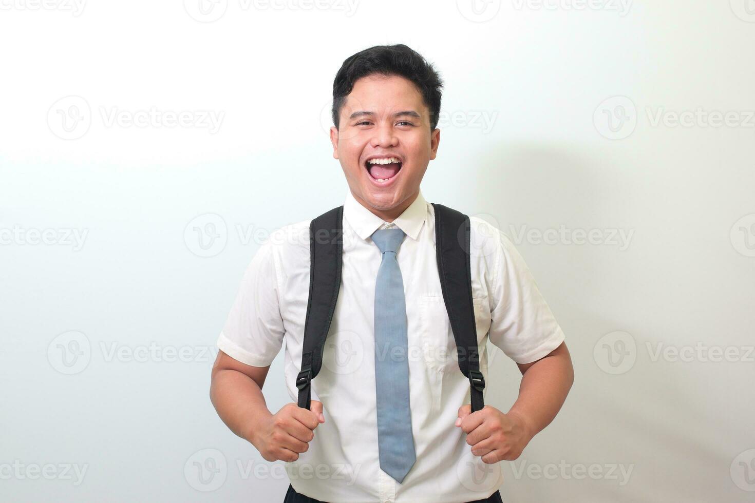 Indonesian senior high school student wearing white shirt uniform with gray tie smiling and looking at camera. Isolated image on white background photo