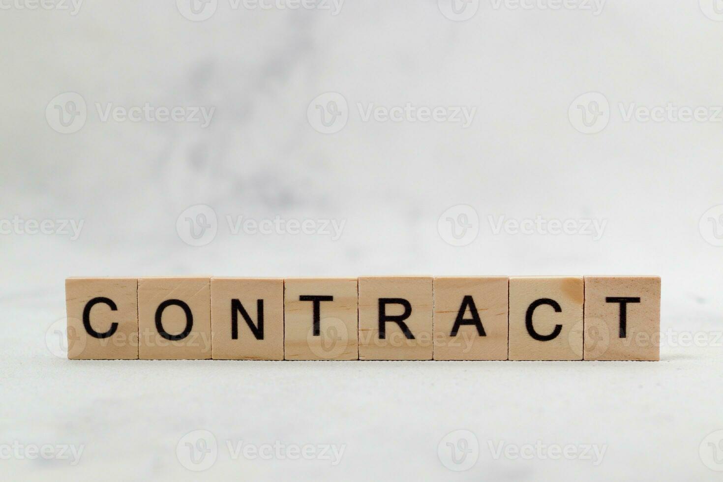 Top view of contract word on wooden cube letter block on white background. Business concept photo