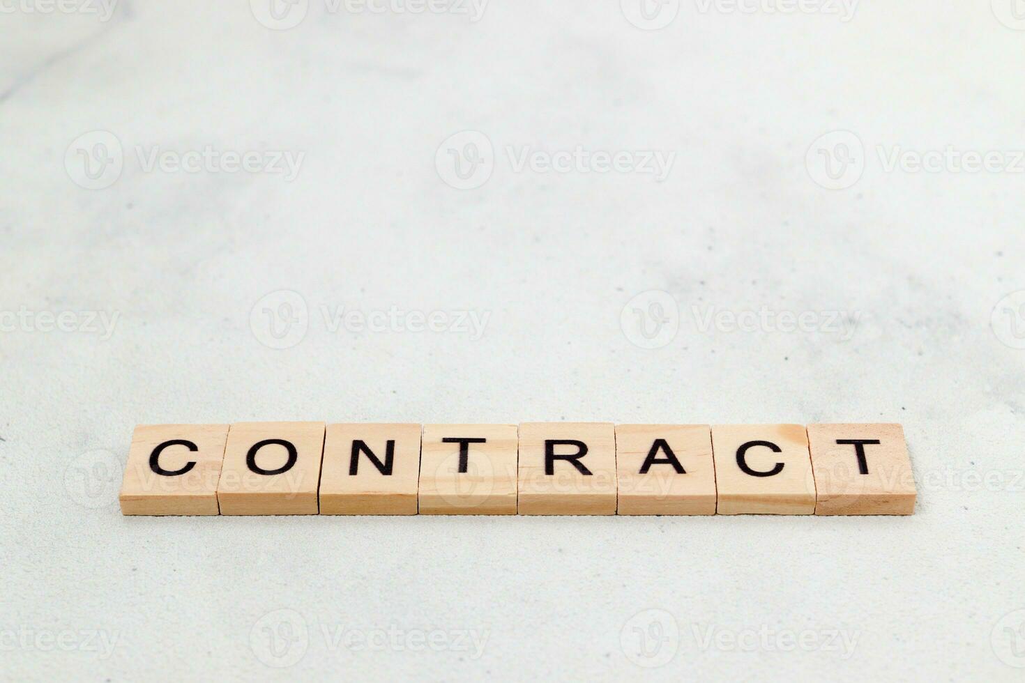 Top view of contract word on wooden cube letter block on white background. Business concept photo