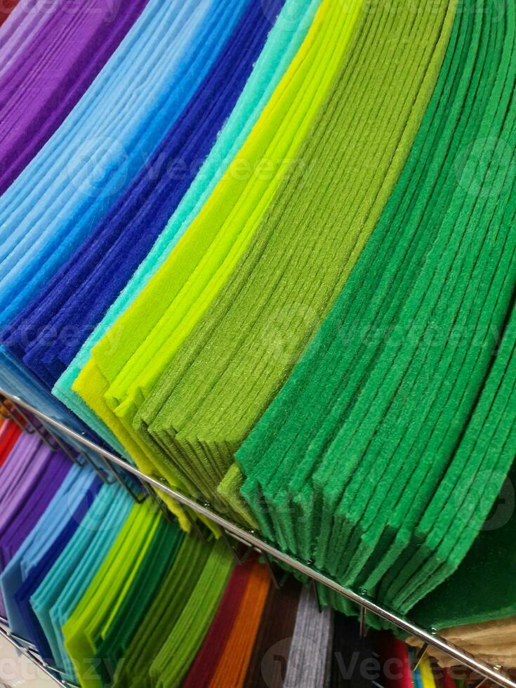 piezas de vistoso textil, muestras de sintió en diferente color para de coser en estantería en el pasatiempo tienda. bricolaje y artesanía concepto foto