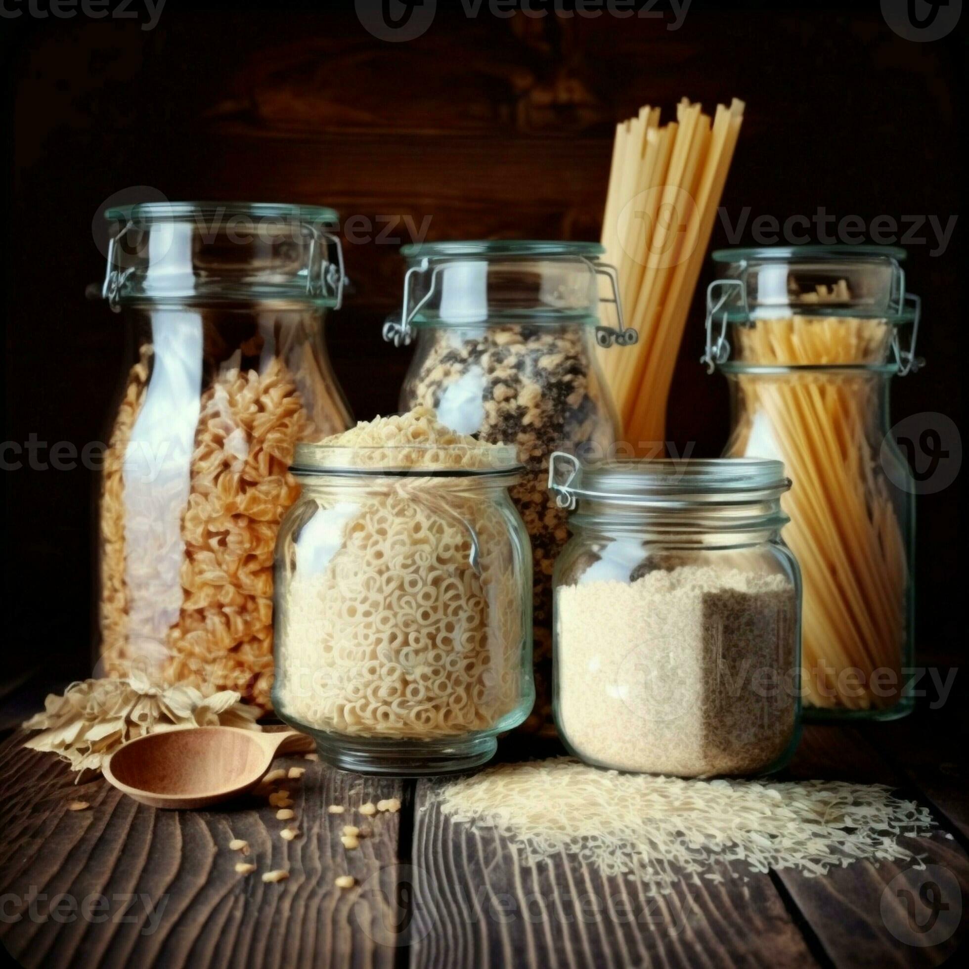 Assortment of grains, cereals and pasta in glass jars on wooden