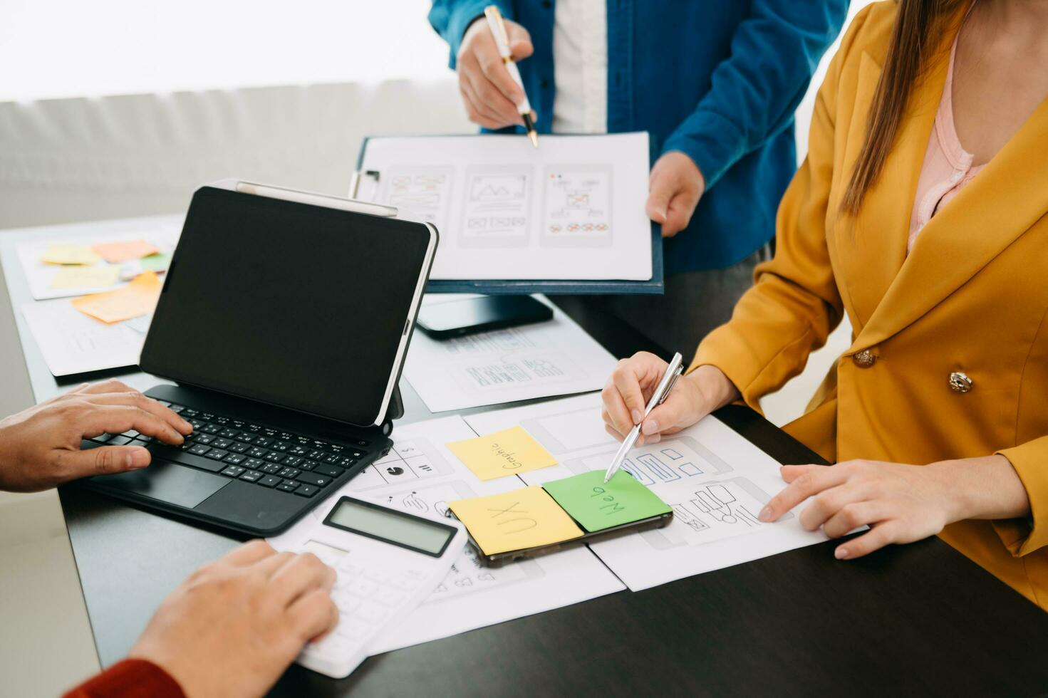 El desarrollador de ux y el diseñador de ui hacen una lluvia de ideas sobre el diseño de la estructura alámbrica de la interfaz de la aplicación móvil con el resumen del cliente y el código de color en la oficina moderna. foto