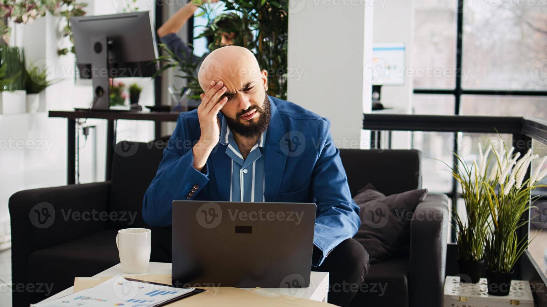 Analyst working with headache in office, feeling unwell and overworked at executive job. Sick businessman not being able to think properly because of painful migraine, project burnout. photo