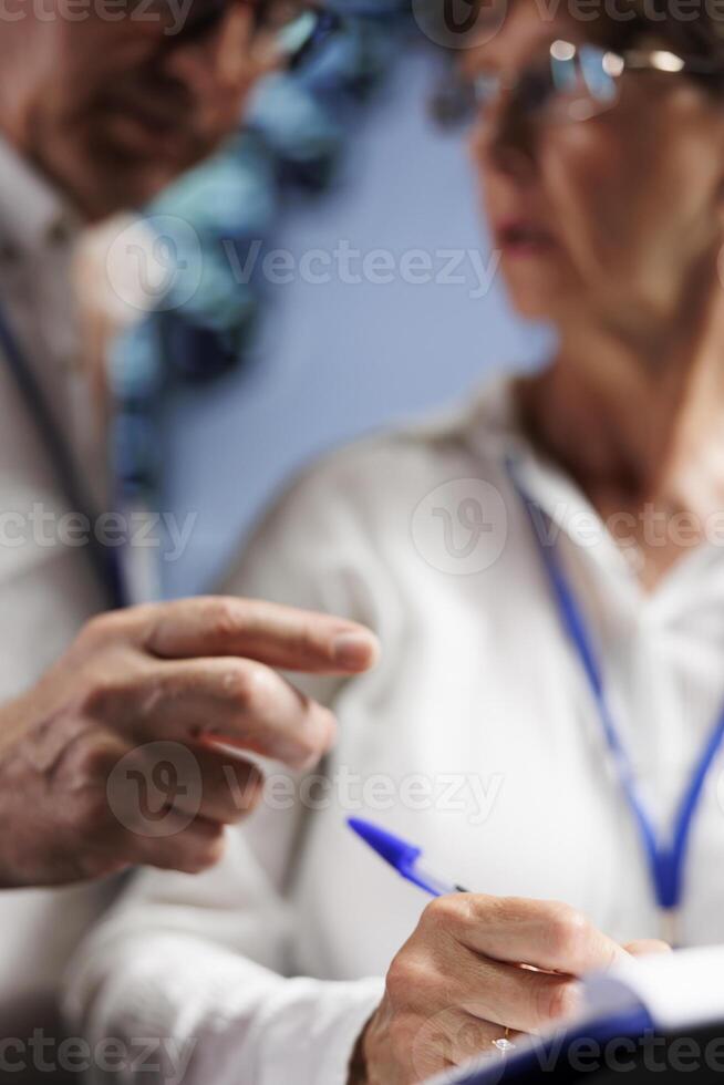 Octogenarian IT developers monitoring server cabinets, optimizing them for data processing requirements of AI applications. Qualified programmers working in high tech space used for machine learning photo