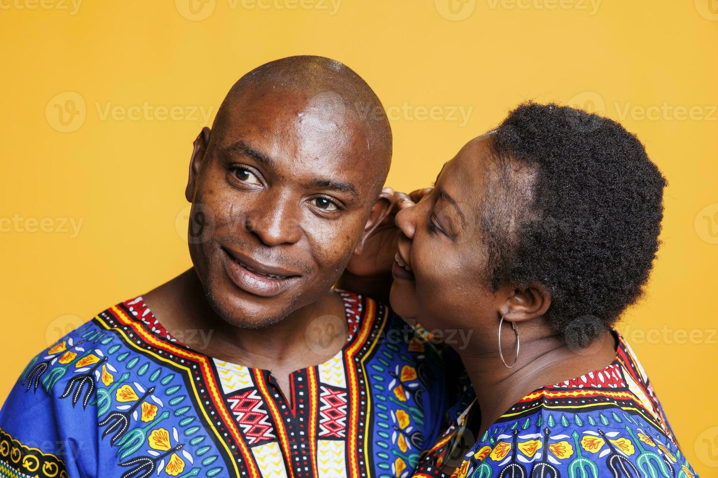 African american man and woman couple sharing secret, expressing love and affection. Black woman whispering to husband ear, telling private romantic message on studio background photo