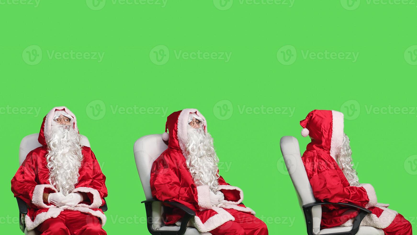 Santa claus character on chair against greenscreen backdrop, cheerful person celebrating christmas eve in red costume. Young adult advertising december holiday with iconic winter suit. photo