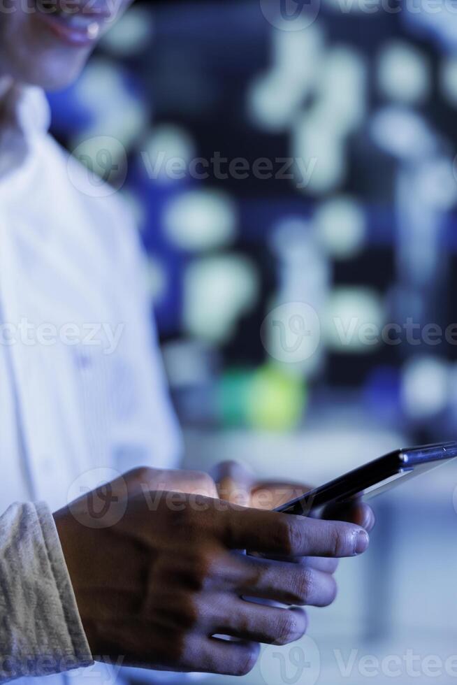 Man strolling around cityscape at night, using smartphone to browse on social media. Relaxed citizen enjoying wandering in empty metropolitan landscape, using cellphone, close up photo