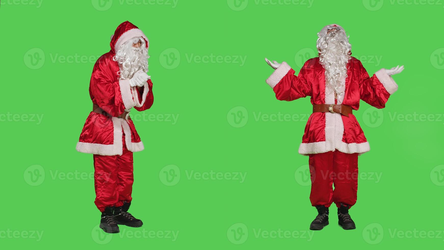 Santa claus praying to god with hands in a prayer, posing over full body greenscreen in studio. Spiritual religious character with festive red suit, talking to jesus advertising christmas holiday. photo