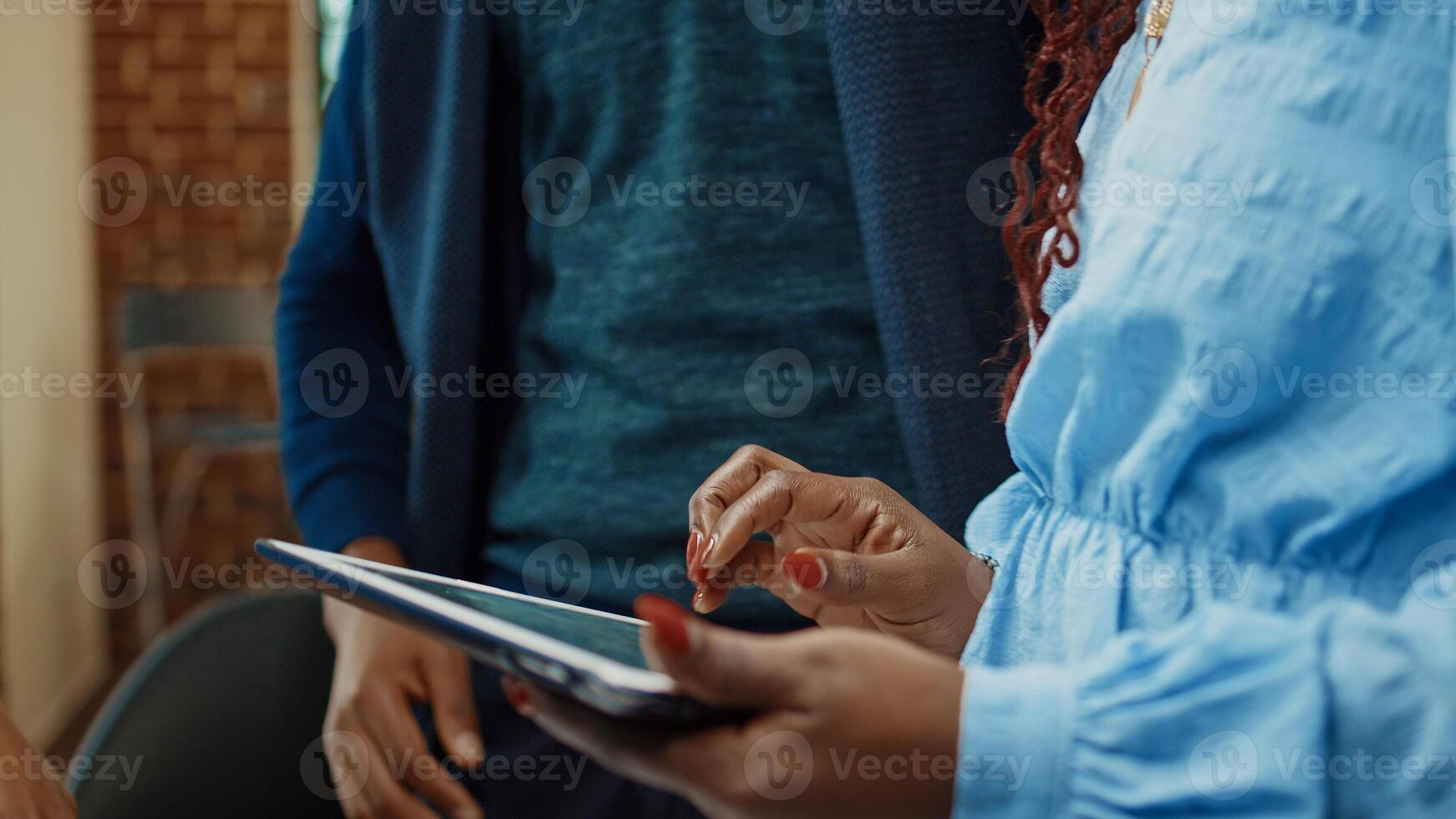 Team of people examining business data on tablet and papers, looking at online analytics for development. Office coworkers doing teamwork planning annual report for executive department. Close up. photo