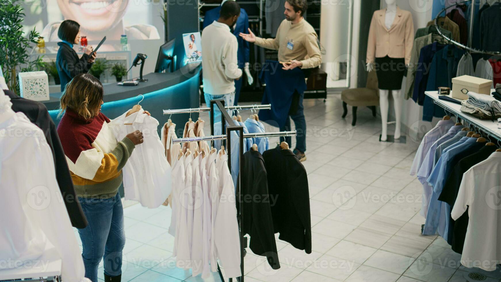 Shopaholic person looking at clothes in retail shop, shopping for new modern collection. Young adult checking merchandise on hangers in clothing store, fashion boutique market. photo