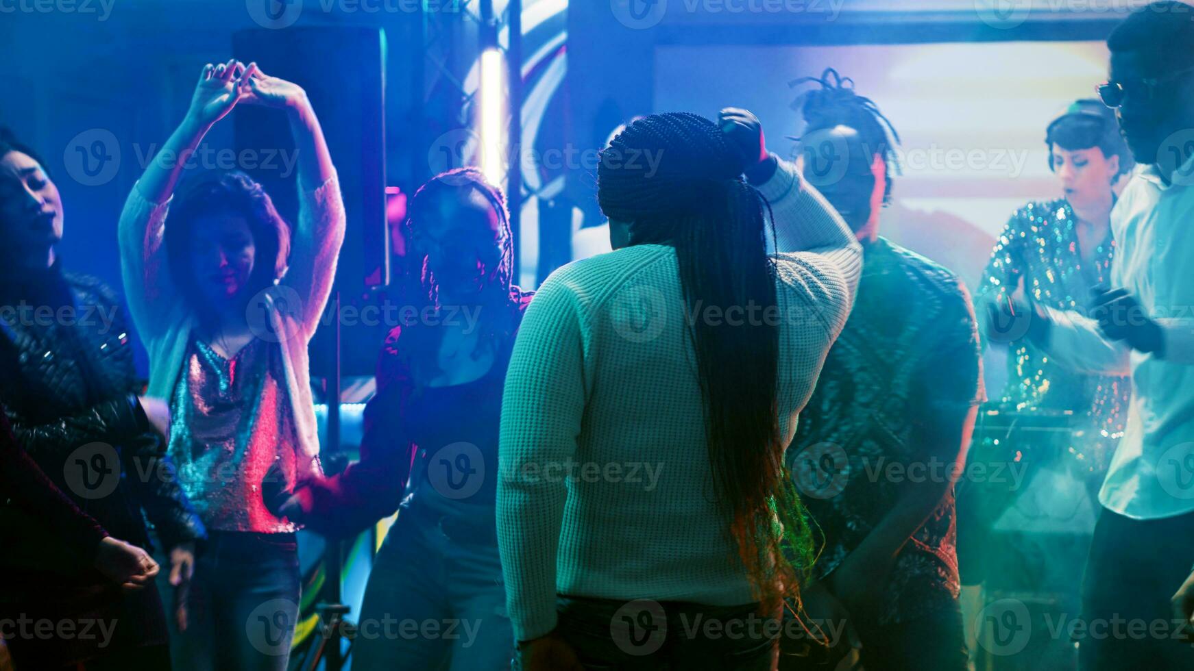 African american person having fun, dancing in the club at social gathering with funky people. Cheerful group of friends listening to music, enjoying party on the dance floor. Tripod shot. photo