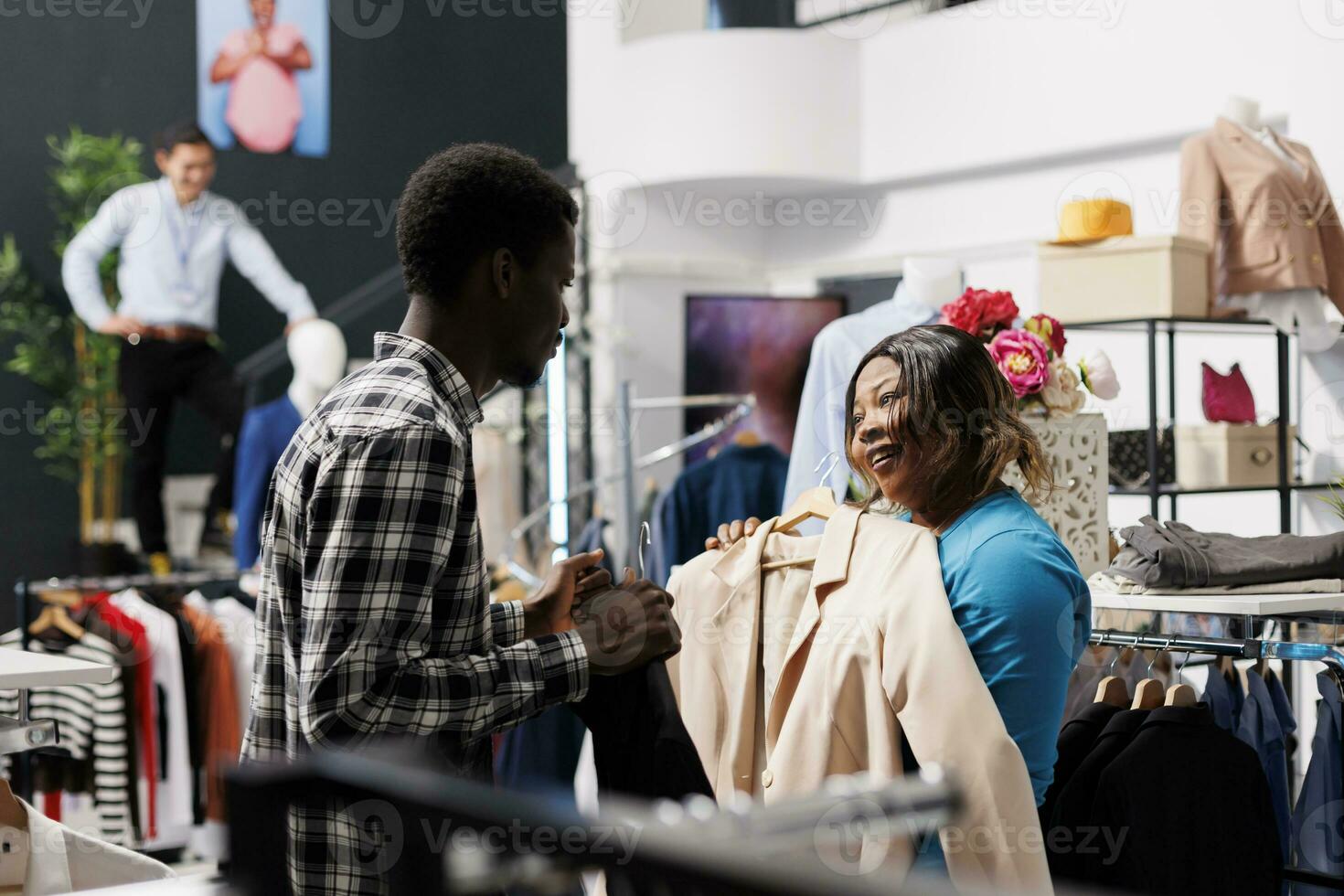 African american man looking at formal shirt, shopping for casual
