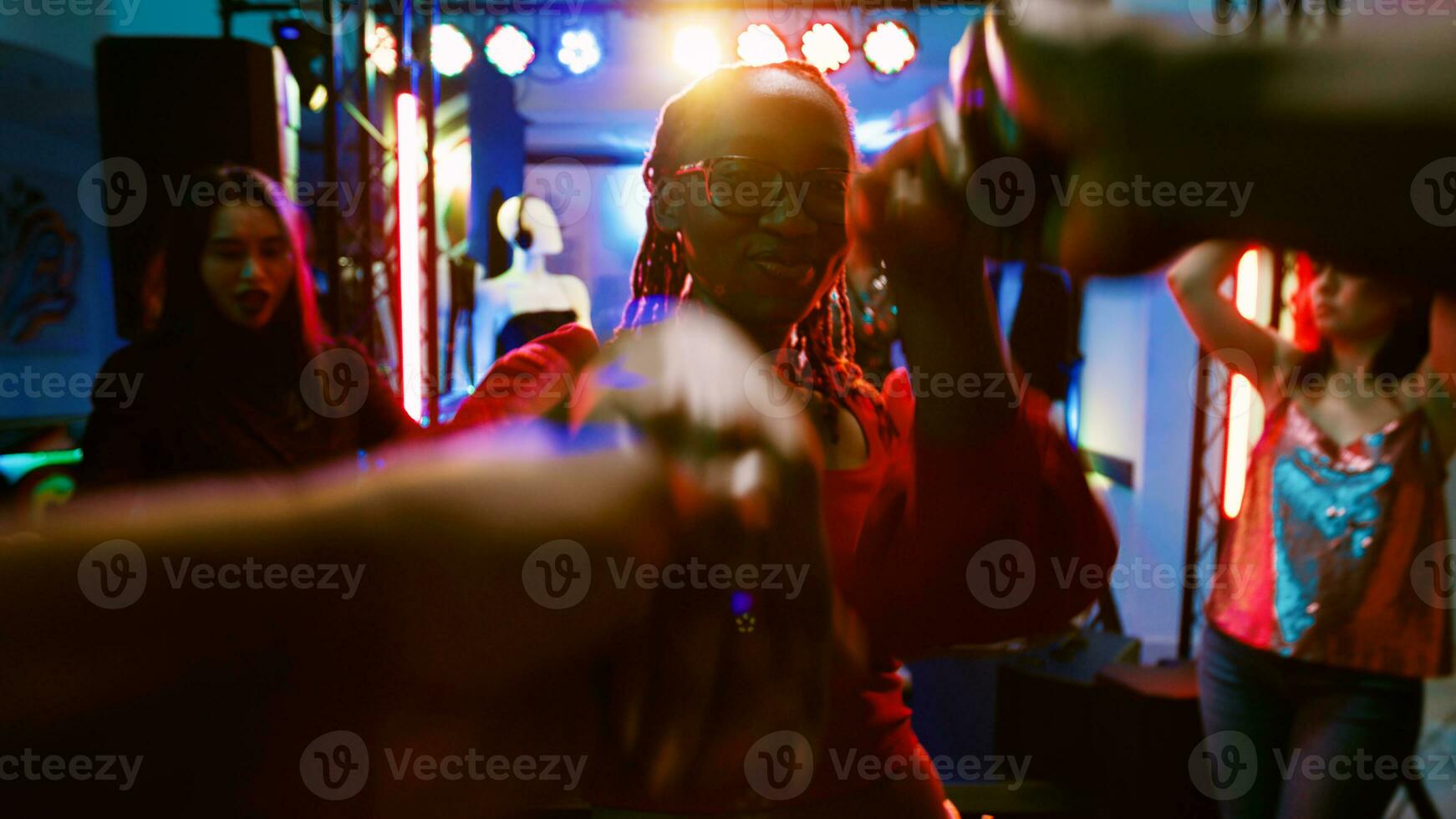 POV of woman dancing with man at party, enjoying disco music on dance floor. Diverse people having fun at nightclub listening to funky beats, social gathering celebration. Handheld shot. photo