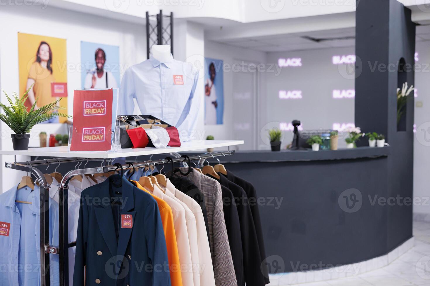 Empty clothing shop with stylish fashionable clothes and accessories at discounted prices waiting for customers on Black Friday. Fashion store decorated with banners and signs for biggest shopping day photo