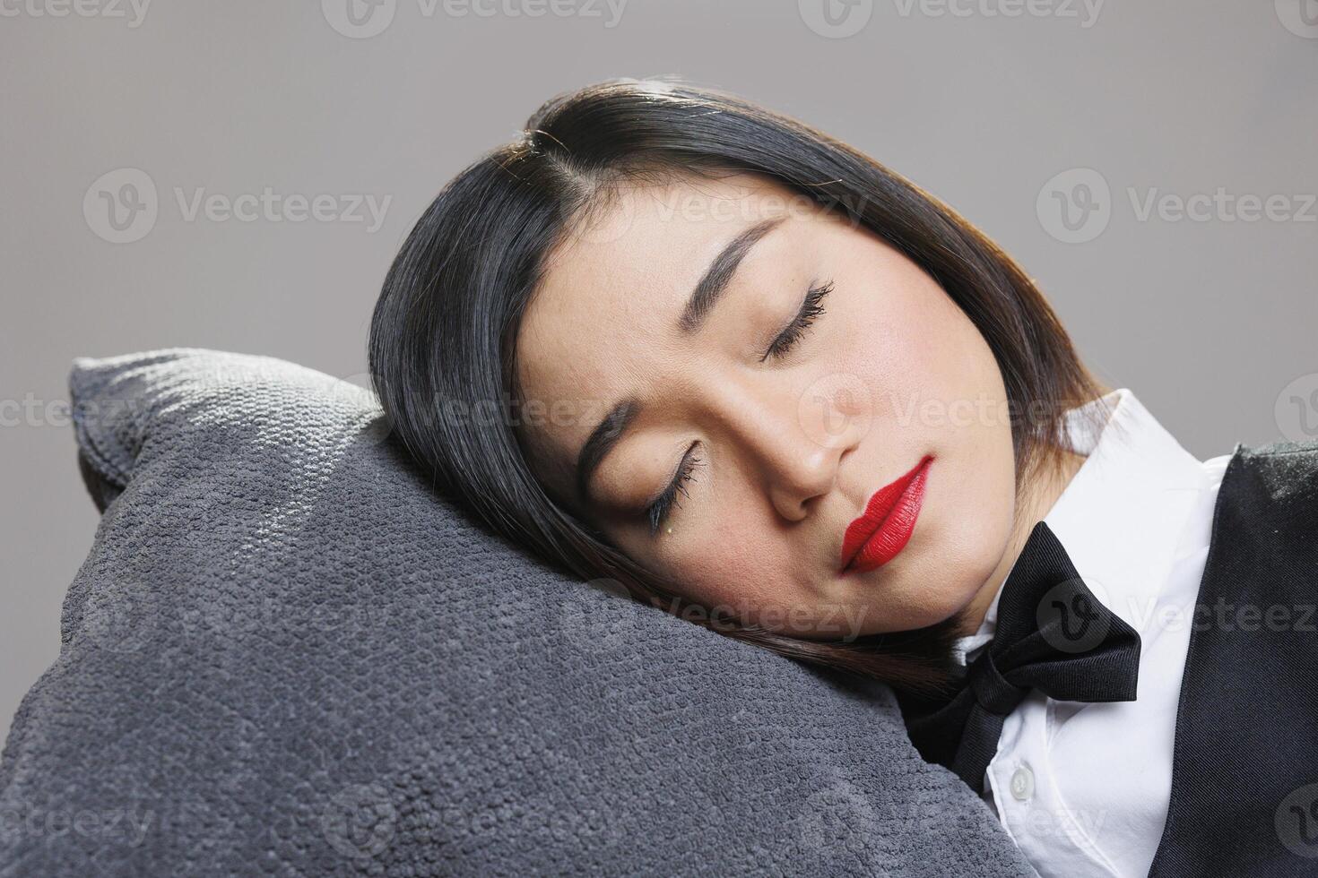 Tired sleepy woman receptionist with closed eyes lying head down on pillow. Restaurant catering service young attractive exhausted asian waitress sleeping and relaxing closeup photo