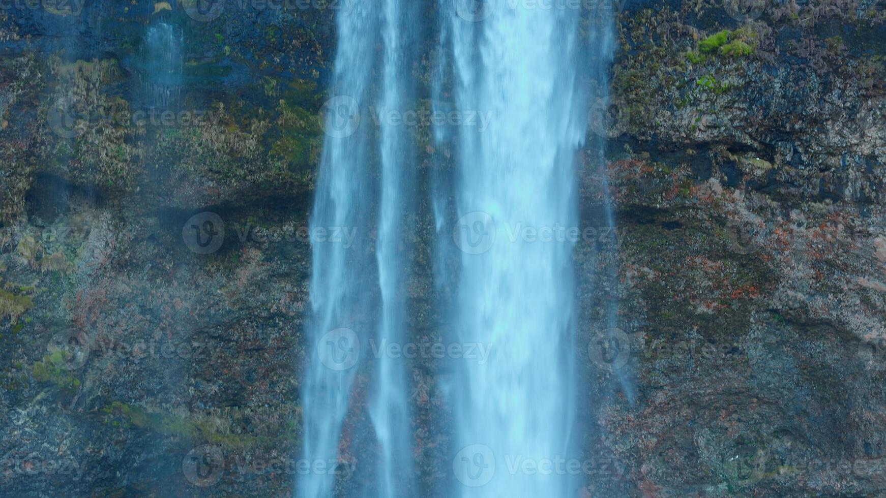 Waterfall in icelandic landscape, seljalandsfoss cascade with water stream falling off of cliff in iceland. Beautiful river flowing down hill in scandinavian scenery, spectacular panoramic view. photo