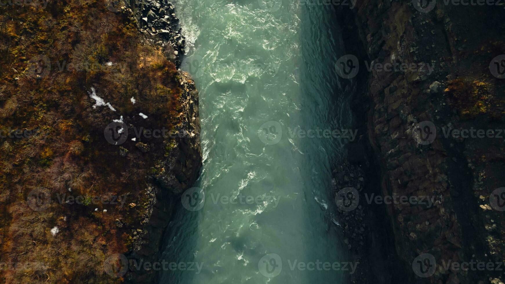 Drone shot of gullfoss cascade river flowing between majestic canyon hills, icelandic landscape. Fantastic scandinavian waterfall creating nordic scenery with nature. Slow motion. photo