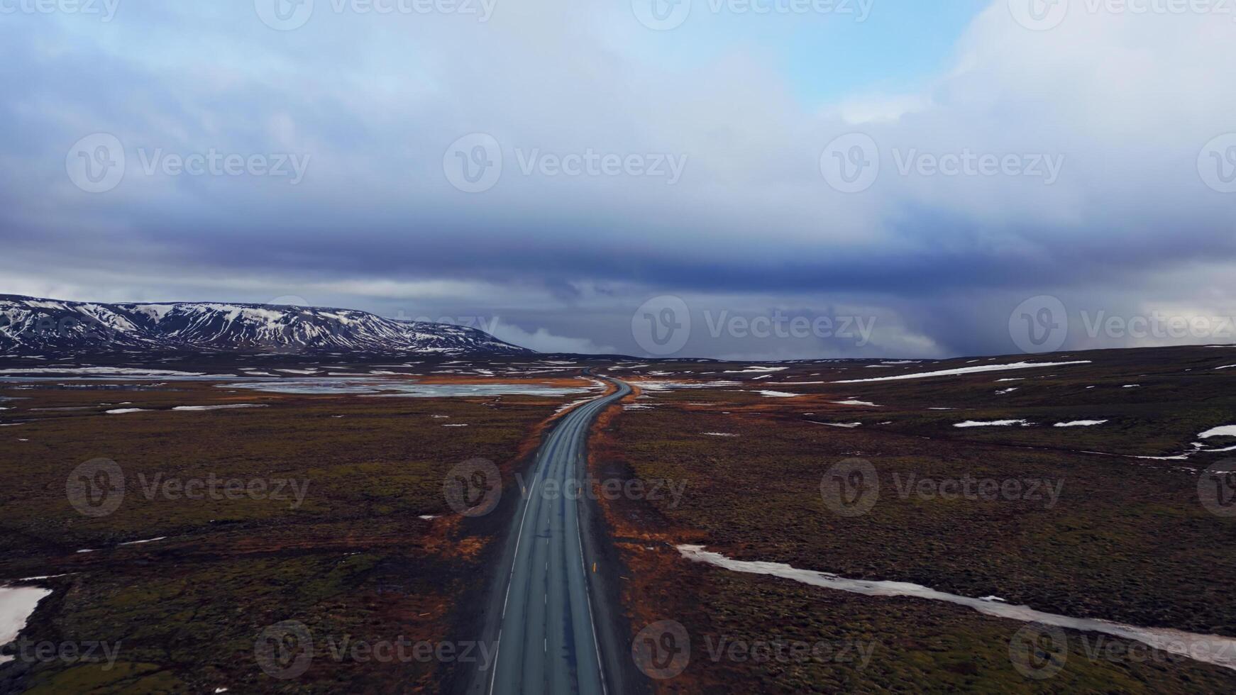 Massive roads between snowy mountains and frozen fields in iceland, drone shot of icelandic roadside with beautiful landscapes. Scandinavian scenic route with hills, winter scenery. photo