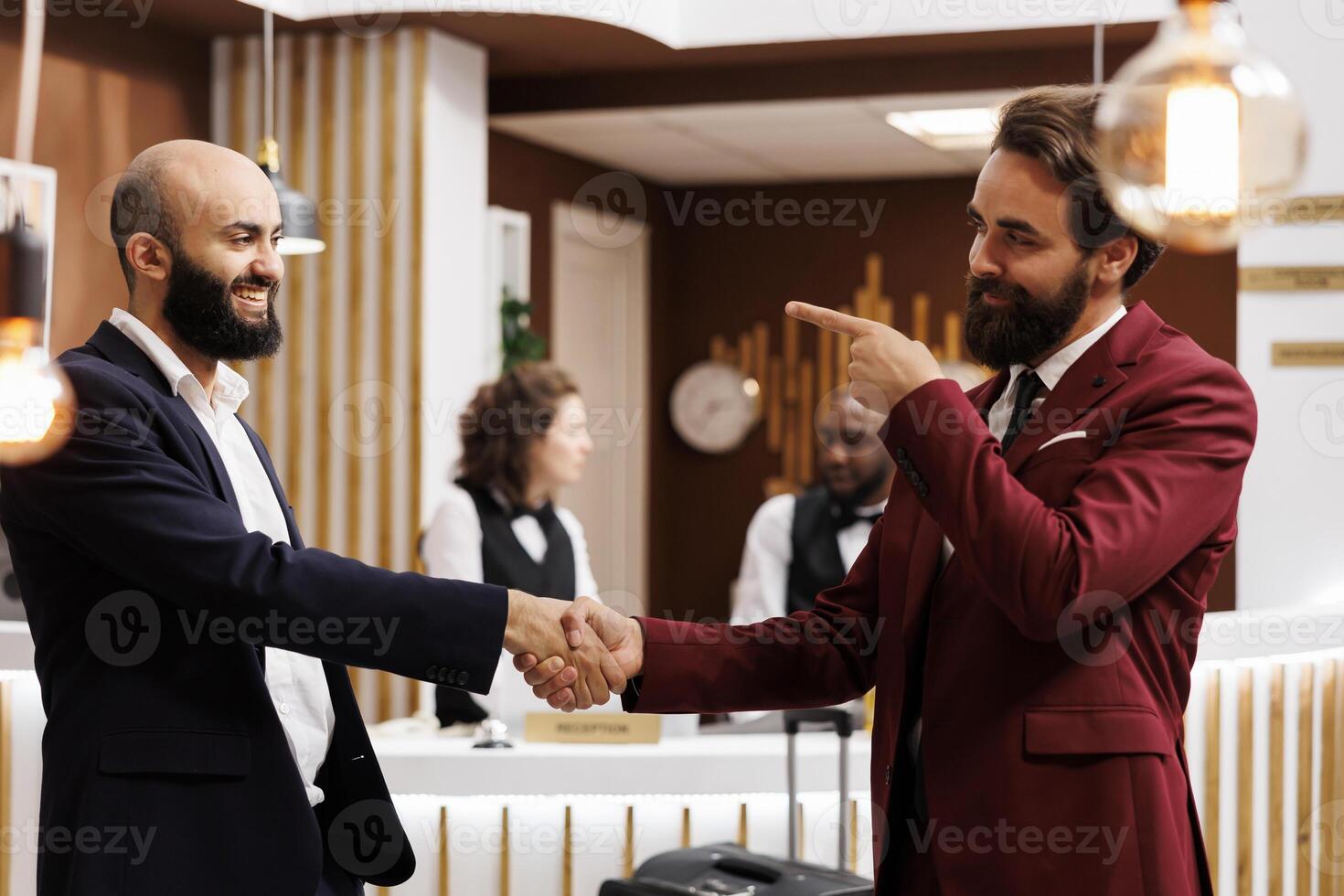 Business collaboration in lounge area at hotel. Professionals meeting to collaborate on project and shaking hands in agreement, creating new alliances internationally. Business trip abroad. photo