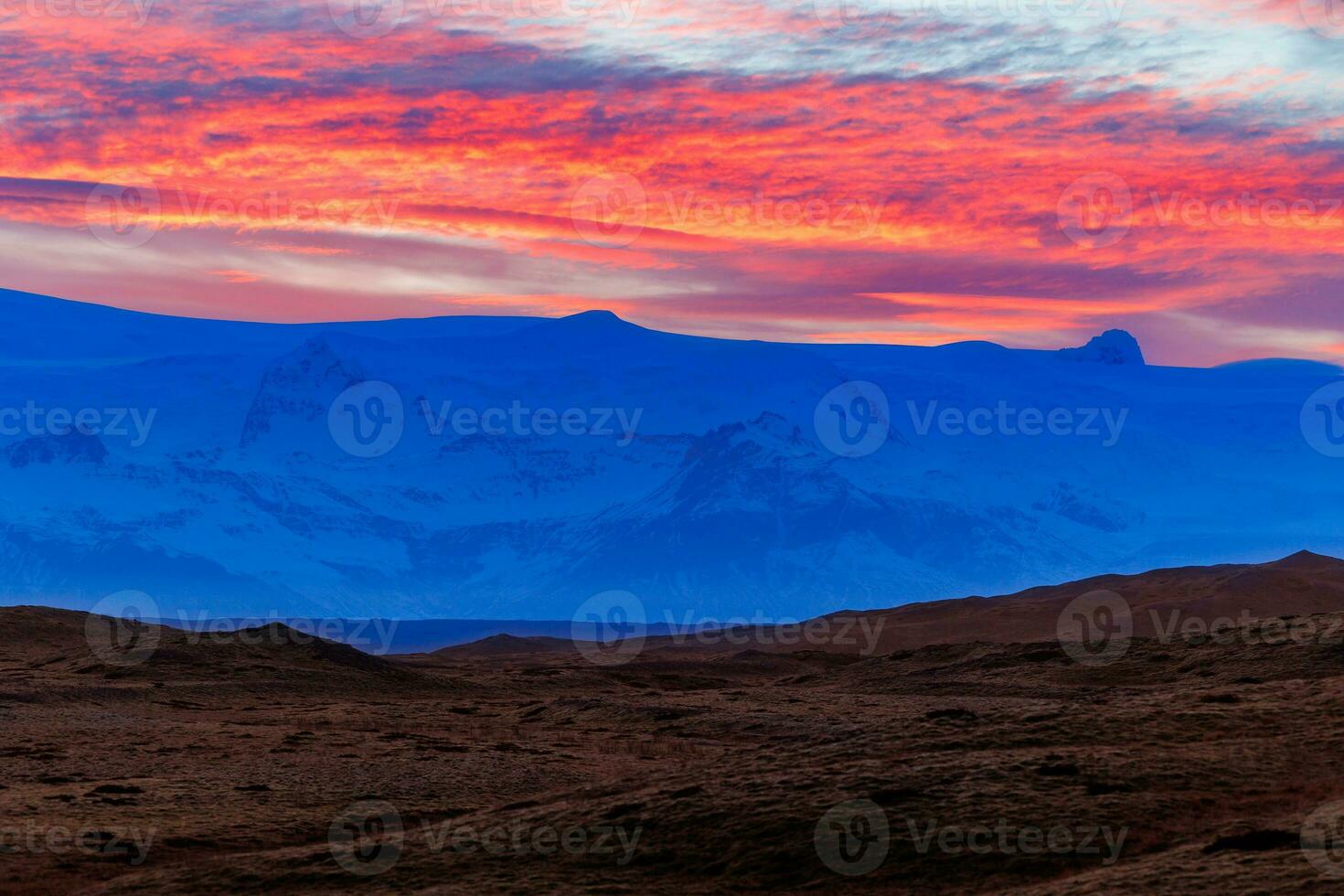 Icelandic chilly highlands with stunning sunset, concept for night photography. Breathtaking view of rosy cotton candy like sky due to sun setting above grand nordic mountain ranges. photo