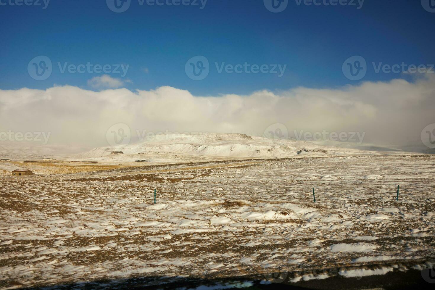 Wintry landscape with frosty cold nature in icelandic region, massive snowy mountains and frozen fields. Winter wonderland roadside scenery with highlands and hills, scenic route. photo