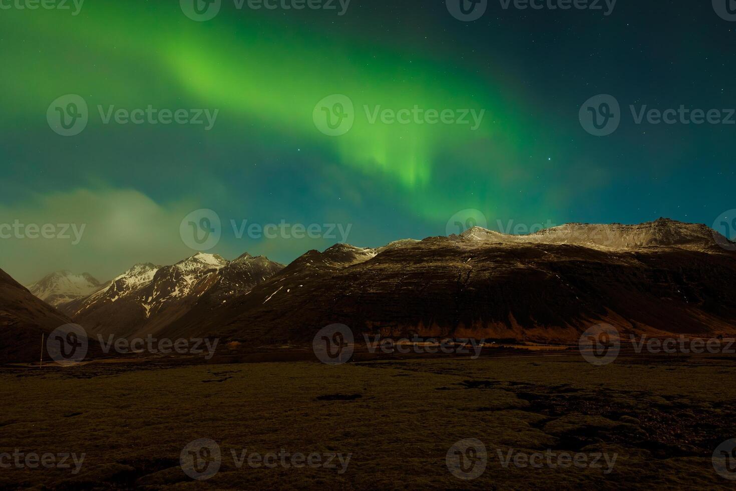 Icelandic scenery with northern lights covering snowy mountain tops, night photography. Nordic aurora borealis illuminating starry sky with green and blue, landscape with captivating panorama. photo