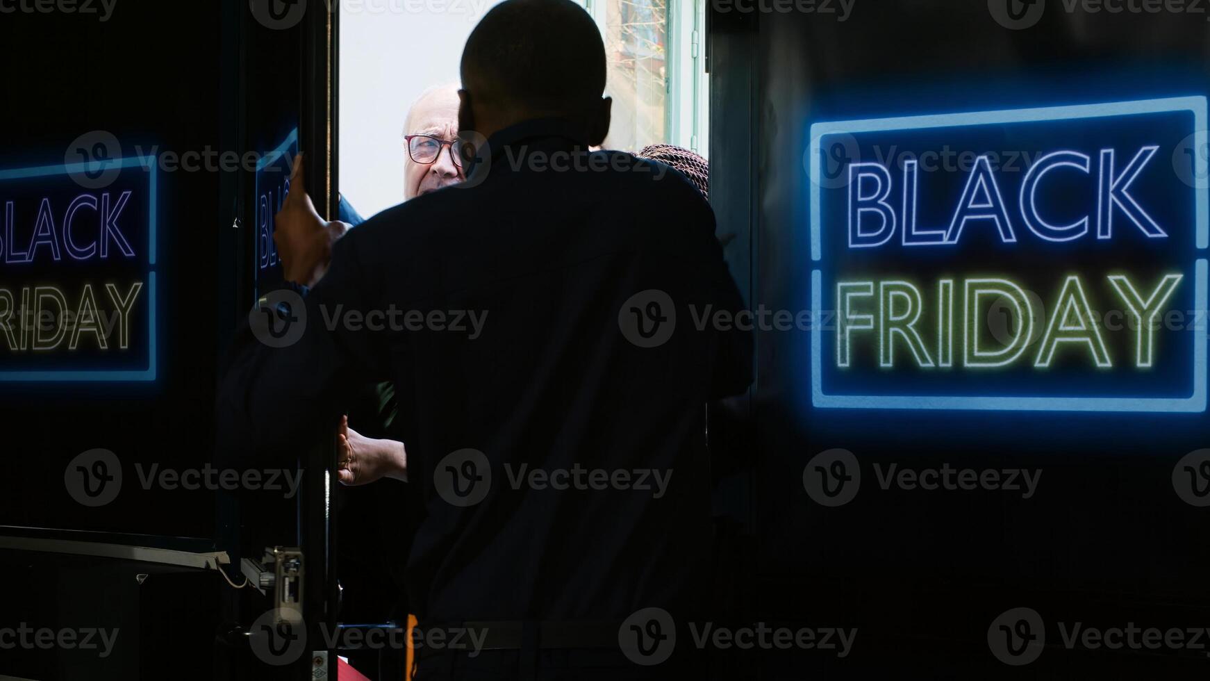 Mad clients breaking into shop during black friday sales at department store, pushing security agent and forcing to enter outlet. Crazy aggressive customers outside shopping center. Tripod shot. photo