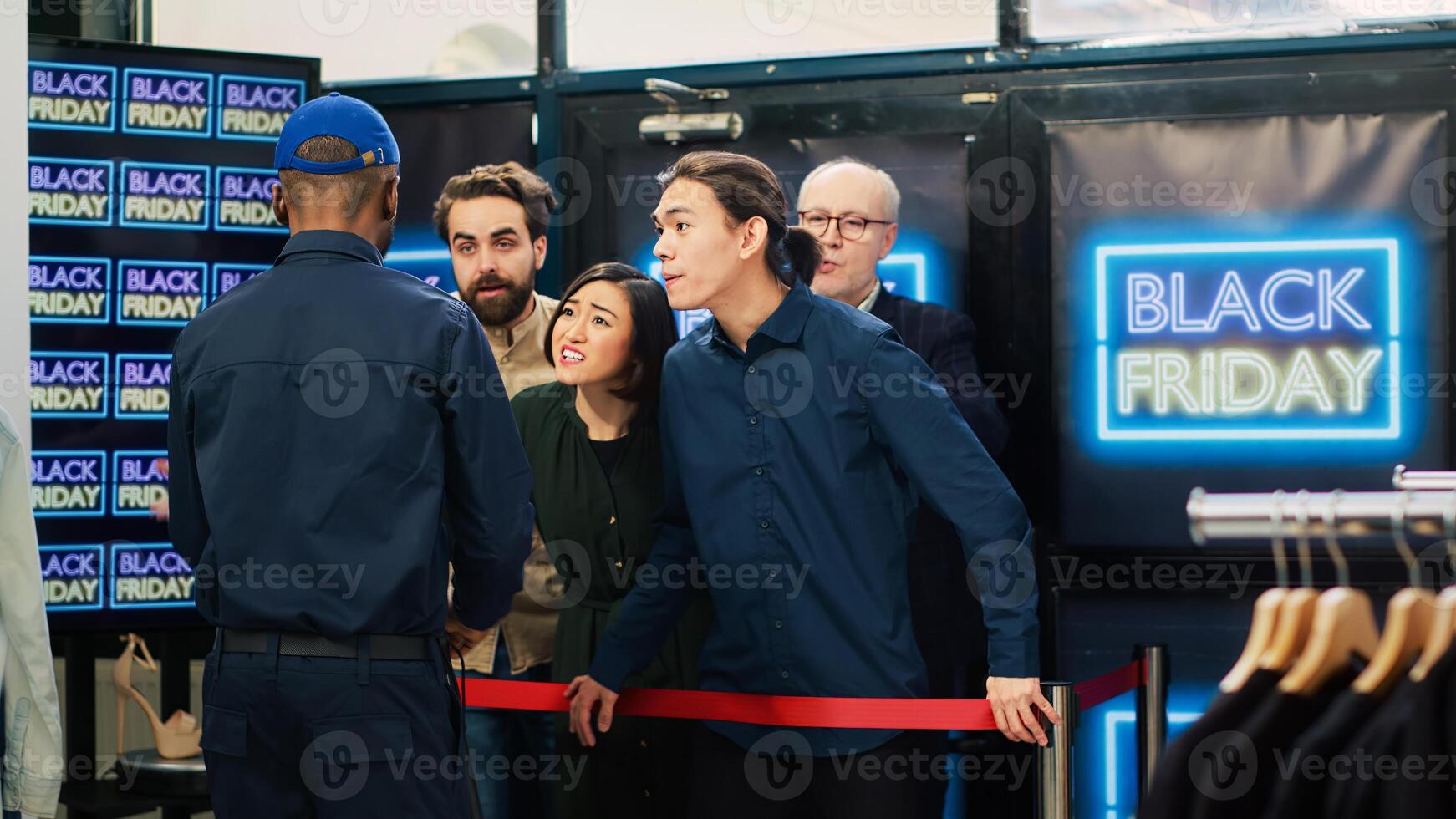 People getting hurt on black friday, opening clothing store during seasonal sales at shopping center. Aggressive people pushing client on the floor, falling in front of red tape. photo